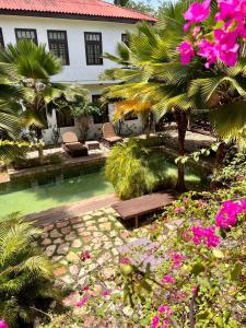 um resort com piscina, palmeiras e flores em Olma Hotel & Suites em Accra