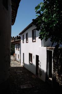 een steegje met een wit gebouw en een boom bij Casa do Javali in Bragança