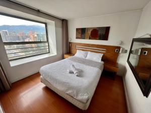 a bedroom with a bed and a large window at Gran Terraza con Vista Apoquindo, Apartamento para 4 Personas, Las Condes in Santiago