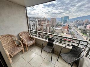 a balcony with chairs and a view of a city at Gran Terraza con Vista Apoquindo, Apartamento para 4 Personas, Las Condes in Santiago