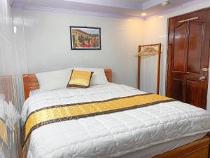 a bedroom with a bed with a yellow pillow on it at My Kim Hotel - Ngay Bến Ninh Kiều in Can Tho