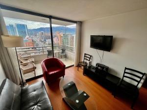 a living room with a couch and a flat screen tv at Gran Terraza con Vista Apoquindo, Apartamento para 4 Personas, Las Condes in Santiago