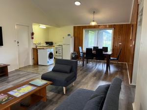 a living room with a couch and a table at Cadel's Cottage WITH FREE UNLIMITED HIGH SPEED INTERNET in Burnt Pine