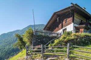 an old wooden house on a hill with stairs at Mountain Chalet Obertreyen in Campo Tures