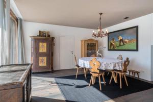 カンポ・トゥーレスにあるMountain Chalet Obertreyenのダイニングルーム(テーブル、椅子、絵画付)