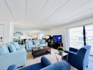 a living room with blue couches and a tv at Beach Front Condo with Spectacular Views in Ocean City