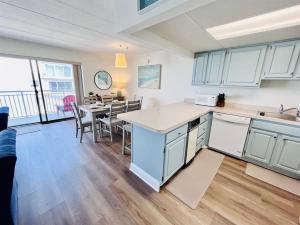 a kitchen with white cabinets and a table with chairs at Beach Front Condo with Spectacular Views in Ocean City