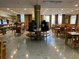 ein Restaurant mit Tischen und Stühlen und einem Kamin in der Unterkunft Actor Hotel Budapest in Budapest