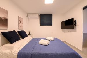 Un dormitorio con una cama con dos toallas encima. en העוגן והים - The Anchor and the Sea, en Shelomi