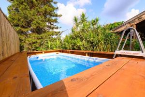 a small swimming pool on a wooden deck with a ladder at העוגן והים - The Anchor and the Sea in Shlomi