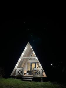 a small house with a triangular roof at night at A Frame house Kryvorivnia in Verkhniy Yasenov