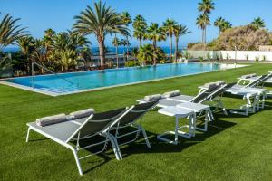 - une rangée de tables et de chaises à côté de la piscine dans l'établissement Abora Interclub Atlantic by Lopesan Hotels, à San Agustín