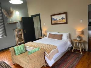 a bedroom with a large bed and a chair at RHOOM in Burgersdorp