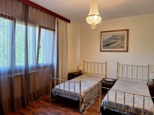 1 dormitorio con 2 camas y lámpara de araña en La Rosa dei Venti, en Duino