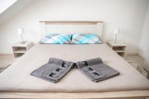 een slaapkamer met een bed met twee handschoenen erop bij Apartman MENHETN Arandjelovac in Arandjelovac