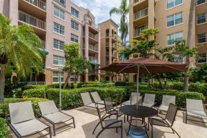 a patio with a table and chairs and an umbrella at Luxury VIP 3 Bed 2 Bath Apartment Yacht Club Aventura in Miami