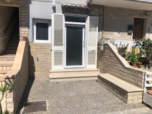 une maison avec une porte blanche et des escaliers dans l'établissement La casa di MeT, à Gallipoli
