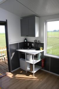 a kitchen with a white counter and a window at Boerenchalet Dirk, Minicamping de Grutte Earen in Burum