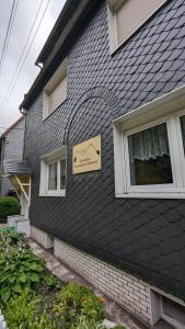 Una casa con un cartel en el costado. en Gästehaus Fehrenbacher Schweiz, en Masserberg