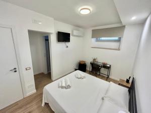 Cette chambre blanche comprend un lit et une télévision. dans l'établissement Sperlonga Sul Mare, à Sperlonga