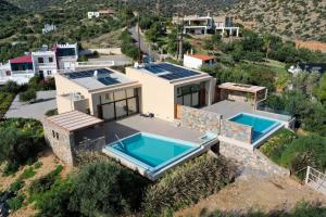 eine Luftansicht eines Hauses mit zwei Swimmingpools in der Unterkunft Mirabella Hills in Agios Nikolaos