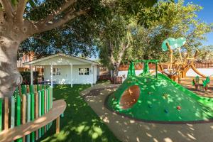 een speeltuin met een groene glijbaan in een park bij Abora Interclub Atlantic by Lopesan Hotels in San Agustin