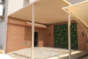 بريفير للأجنحة الفندقية Privere Hotel Suites في الرياض: منزل مع تحوط أخضر على الواجهة