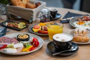 a table topped with plates of food and cups of coffee at Elements Resort Zell am See; BW Signature Collection in Zell am See