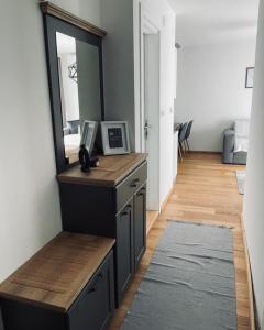 a room with a mirror and a dresser with a mirror at Gray apartman in Vrnjačka Banja