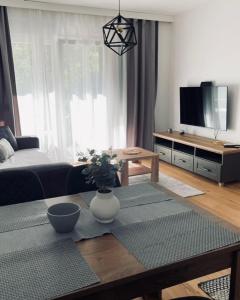 a living room with a coffee table and a tv at Gray apartman in Vrnjačka Banja