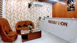 eine Lobby mit 2 Stühlen und einer Rezeption in der Unterkunft The Signature Hotel Multan in Multan