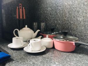 a group of tea pots and pans on a counter at Sathis villa in Ambalangoda