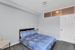 een slaapkamer met een bed met een blauw dekbed bij Entire flat in heart of Chelsea hosted by Zahra in Londen