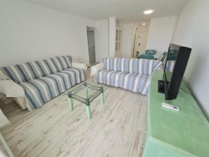 Una sala de estar con dos sofás y un televisor de pantalla plana. en Apartamento 1134, en Zahara de los Atunes
