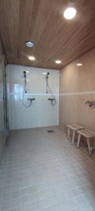 a bathroom with a shower and a bench in a room at Villa Koivikko in Rovaniemi