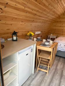 a kitchen with a table and a bed in a room at Wind In The Willows Luxury Glamping in Peterborough