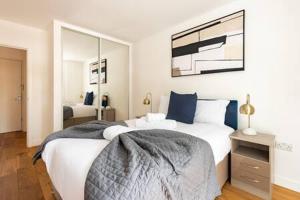 a bedroom with a large bed and a mirror at Stylish East London Flat MS2 in London