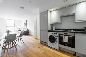 a kitchen with a stove and a table with chairs at Stylish East London Flat MS2 in London