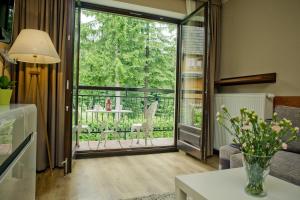 - un salon avec une grande porte en verre menant à une terrasse dans l'établissement Apart4You Apartamenty Bulwary25, à Zakopane