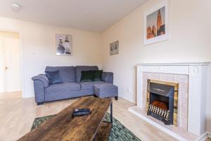 a living room with a couch and a fireplace at Thorley Court, Swindon in Swindon