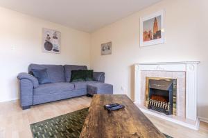 a living room with a couch and a fireplace at Thorley Court, Swindon in Swindon