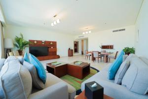 ein Wohnzimmer mit einem Sofa und einem TV in der Unterkunft Blue Beach Tower The Walk JBR in Dubai