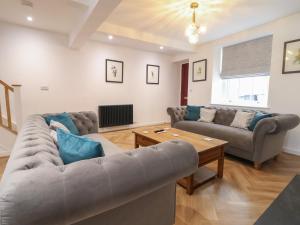 a living room with two couches and a table at Neptune Cottage in Conwy