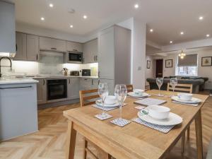a kitchen and dining room with a wooden table and chairs at Neptune Cottage in Conwy
