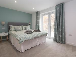 a bedroom with a bed and a large window at Neptune Cottage in Conwy