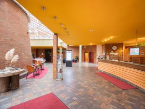 een lobby van een gebouw met een geel plafond bij Mühlenhotel Halle-Leipzig in Landsberg