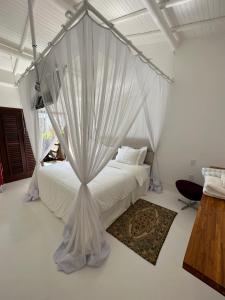 a bedroom with a bed with mosquito netting at Casa Downtown in Caraíva