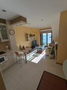 uma cozinha e sala de estar com mesa e cadeiras em Mirador Mar de Castelao, 1ª línea de playa urbana em Vilanova de Arousa