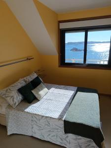 1 dormitorio con 1 cama y ventana grande en Mirador Mar de Castelao, 1ª línea de playa urbana, en Villanueva de Arosa