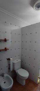 a bathroom with a white toilet and a sink at La Lobera Alojamiento Rural in Riópar +4 photos